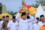 Salah seorang peserta tampak antusias menjunjung hidangan buah saat mengikuti Parade Hidang Maulid di Lapangan Blang Padang, Banda Aceh, Senin (24/11/2025). (Foto: Dok. Humas Pemko Banda Aceh).