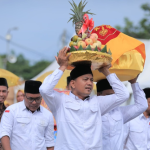 Salah seorang peserta tampak antusias menjunjung hidangan buah saat mengikuti Parade Hidang Maulid di Lapangan Blang Padang, Banda Aceh, Senin (24/11/2025). (Foto: Dok. Humas Pemko Banda Aceh).