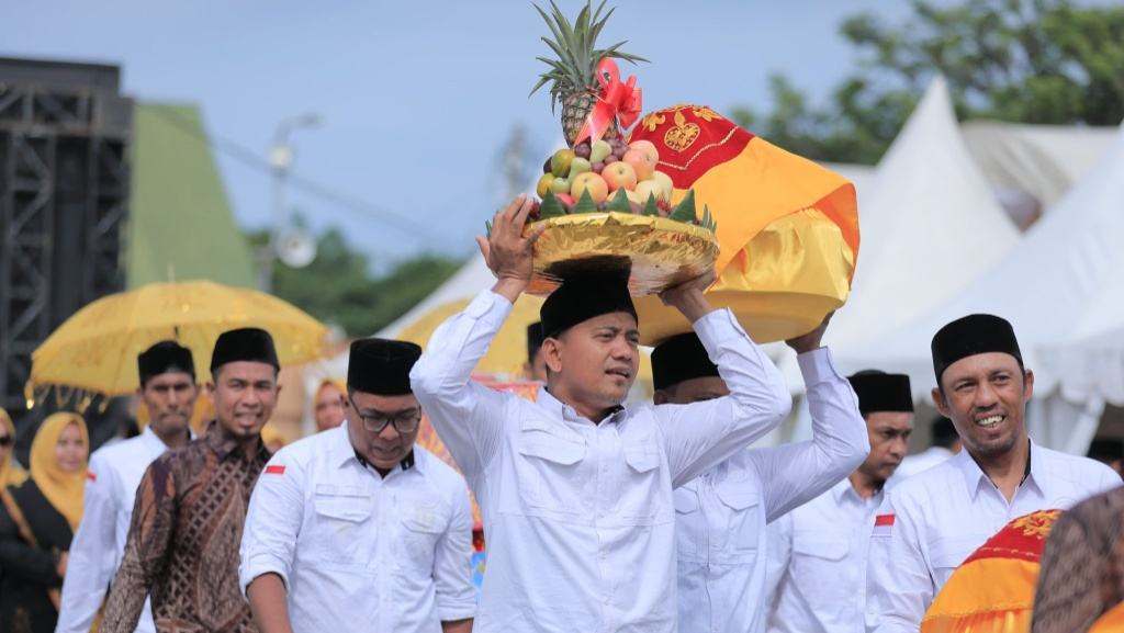 Salah seorang peserta tampak antusias menjunjung hidangan buah saat mengikuti Parade Hidang Maulid di Lapangan Blang Padang Banda Aceh Senin 24112025 Foto Dok Humas Pemko Banda Aceh